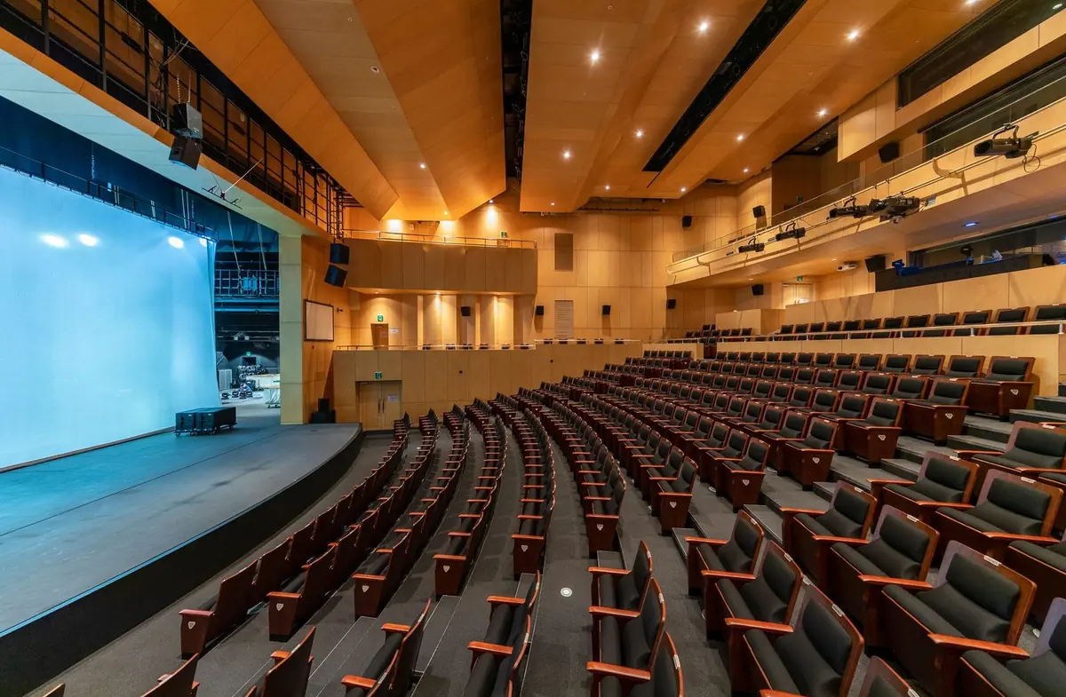 Interior del auditorio del colegio con butacas y escenario listo para una presentación