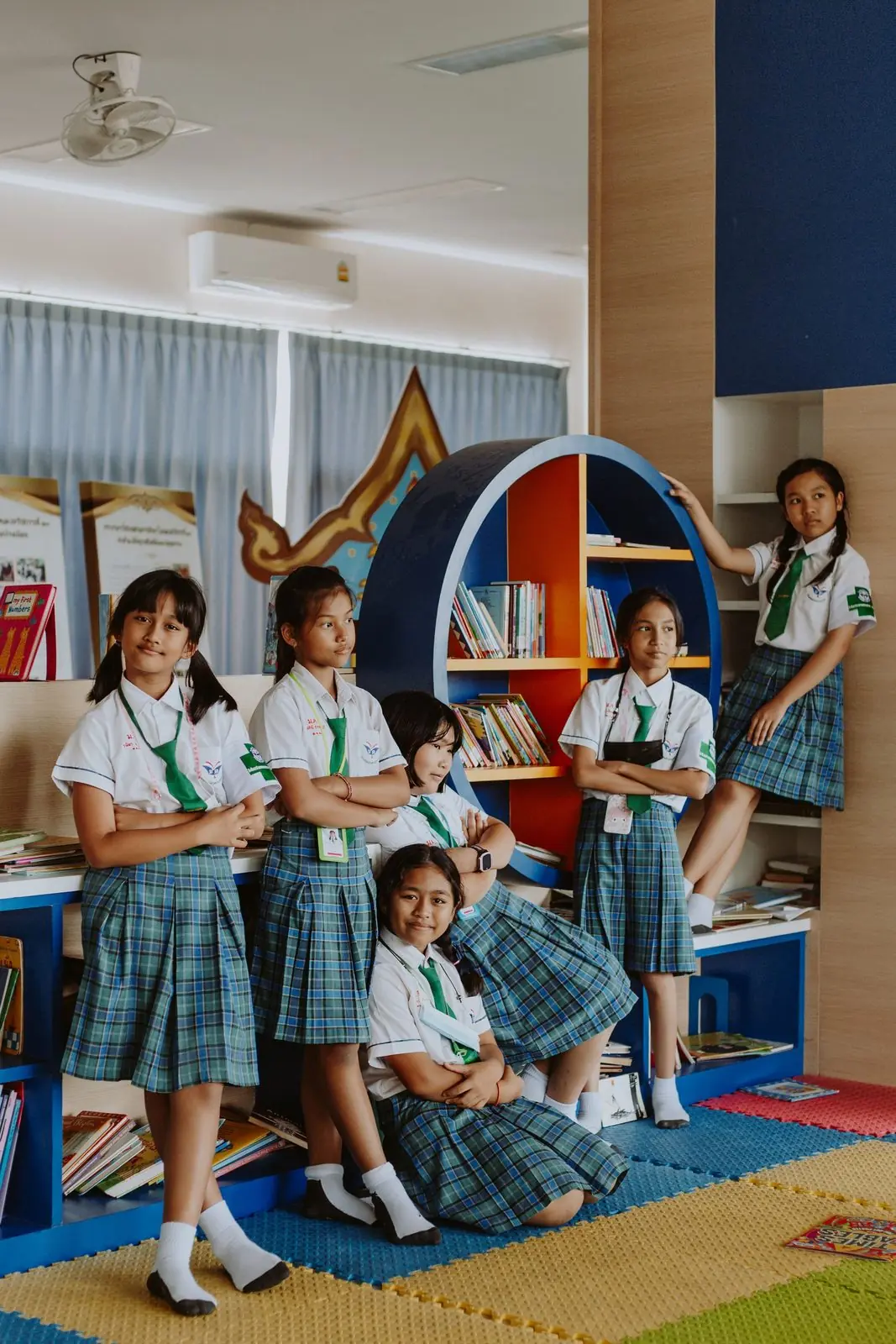 Estudiantes sentados en las gradas de la biblioteca durante una actividad de lectura