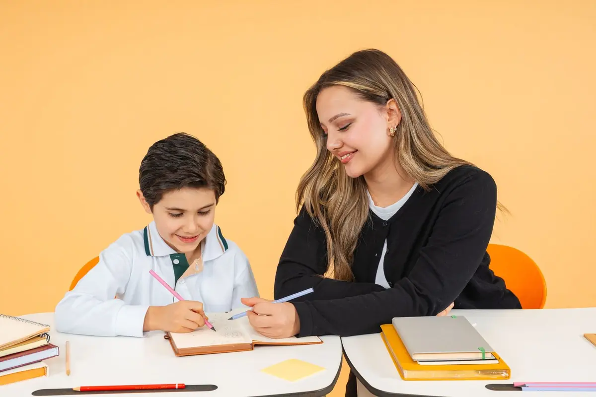 Profesora orientando a un estudiante en su carpeta de trabajo